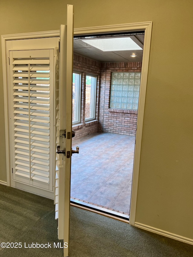9802 Toledo Ave, Lubbock, TX 79424 - doorway to outside with brick wall and carpet flooring