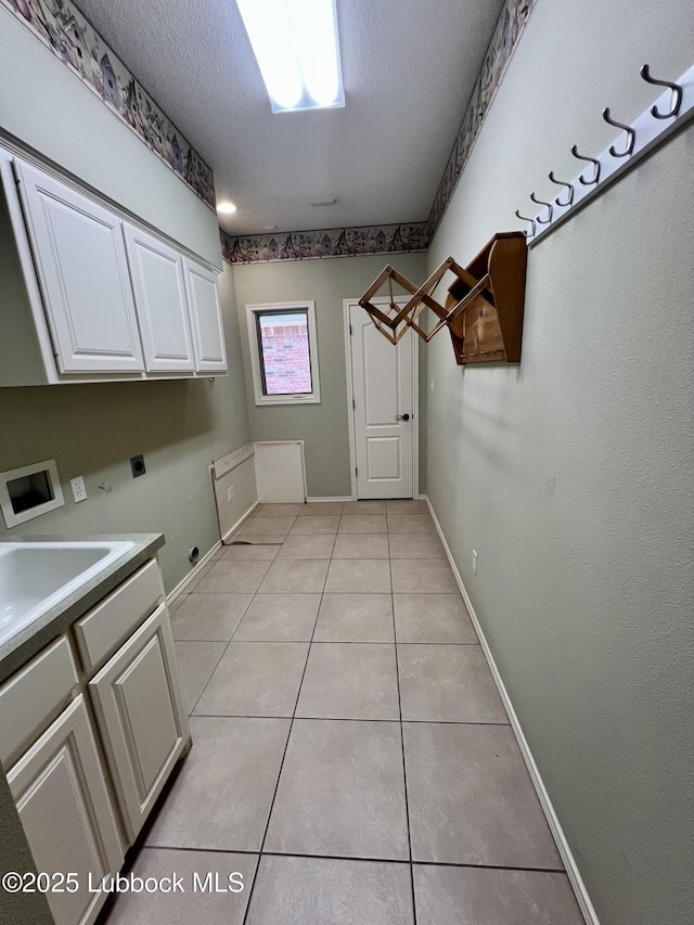 9802 Toledo Ave, Lubbock, TX 79424 - washroom featuring cabinet space, light tile patterned floors, a textured ceiling, electric dryer hookup, and washer hookup
