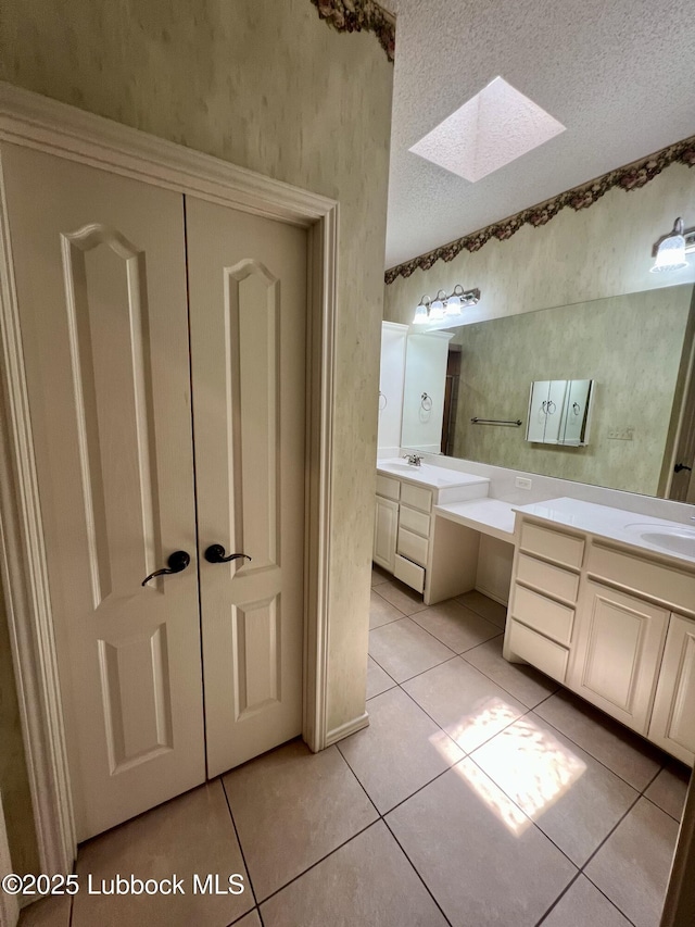 9802 Toledo Ave, Lubbock, TX 79424 - bathroom with a skylight, double vanity, and tile patterned flooring