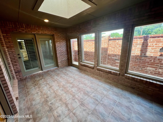 9802 Toledo Ave, Lubbock, TX 79424 - unfurnished sunroom with brick wall, a skylight, and recessed lighting