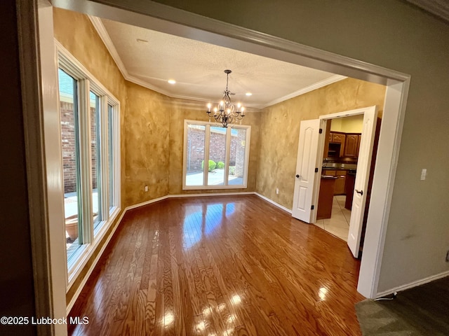 9802 Toledo Ave, Lubbock, TX 79424 - unfurnished dining area featuring healthy amount of natural light, a chandelier, wood finished floors, and ornamental molding
