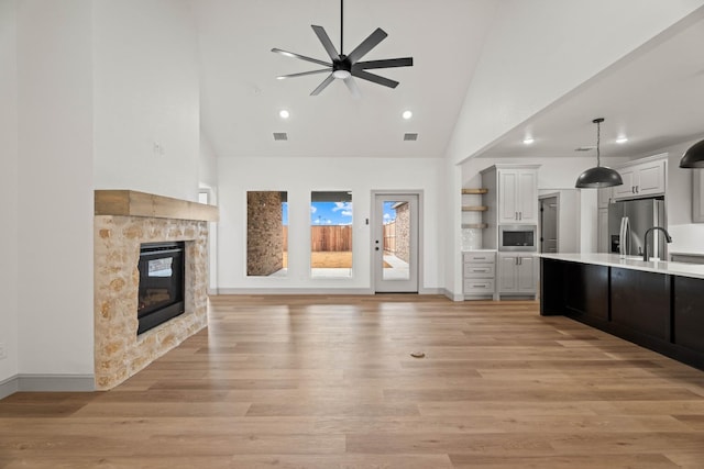 kitchen featuring appliances with stainless steel finishes, a fireplace, light hardwood / wood-style floors, and white cabinets