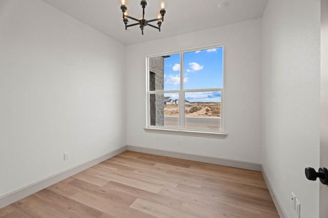 unfurnished room featuring light hardwood / wood-style floors and a notable chandelier