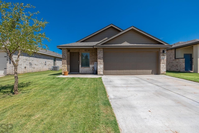 view of front of property featuring a garage, a front lawn, and central air condition unit