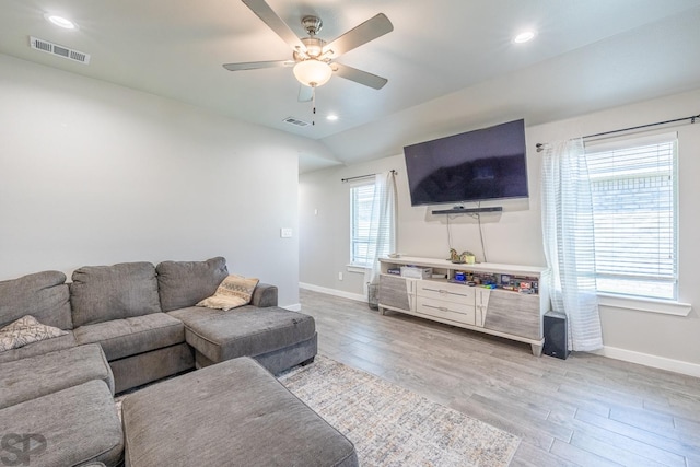 living room with lofted ceiling, plenty of natural light, ceiling fan, and light wood-type flooring