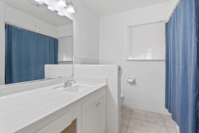 bathroom featuring vanity, toilet, tile patterned flooring, and tile walls