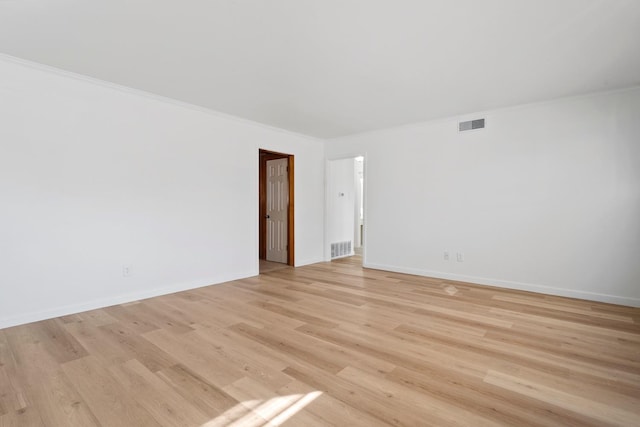 unfurnished room with ornamental molding and light hardwood / wood-style floors