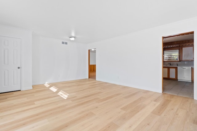 spare room featuring sink, ornamental molding, and light wood-type flooring