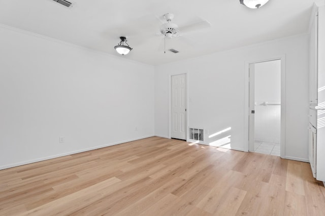 spare room with ceiling fan, ornamental molding, and light wood-type flooring