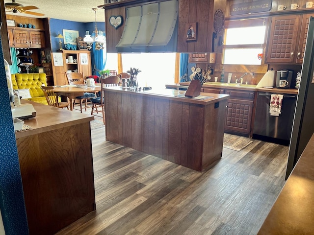 kitchen with dishwasher, hanging light fixtures, dark hardwood / wood-style floors, ventilation hood, and a textured ceiling