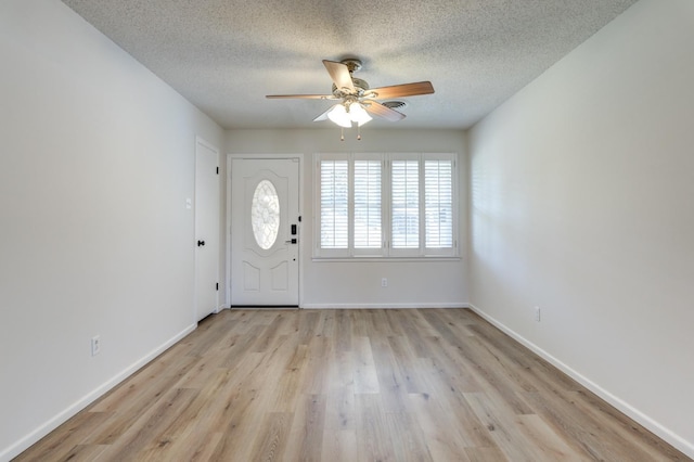 foyer with ceiling fan, a textured ceiling, and light wood-type flooring