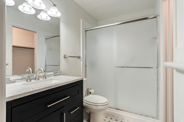 bathroom with vanity, toilet, and a shower with shower door