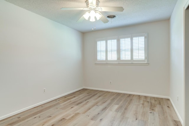 unfurnished room featuring ceiling fan, light wood-type flooring, and a textured ceiling