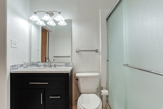 bathroom featuring vanity, toilet, and an enclosed shower