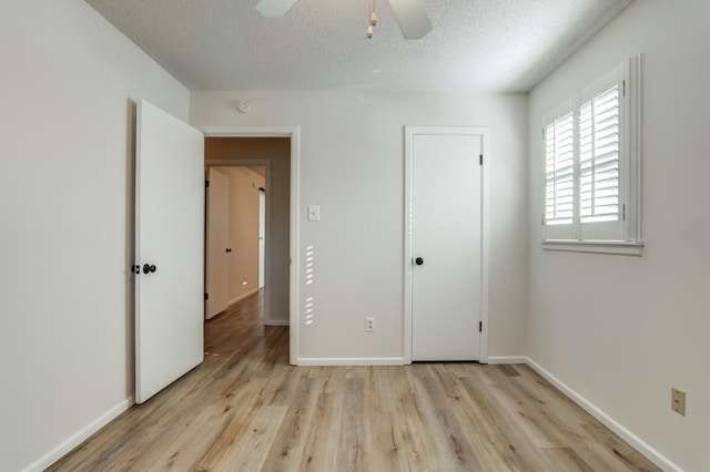 unfurnished bedroom with ceiling fan, a textured ceiling, and light hardwood / wood-style floors