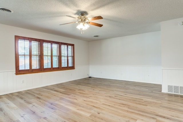 unfurnished room featuring ceiling fan, a textured ceiling, and light wood-type flooring