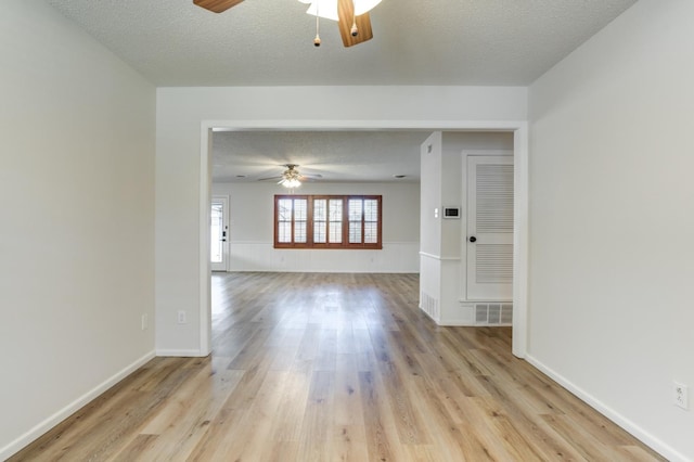 empty room featuring ceiling fan, a textured ceiling, and light wood-type flooring