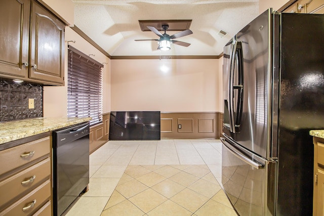 kitchen with a ceiling fan, wainscoting, vaulted ceiling, black appliances, and light tile patterned flooring