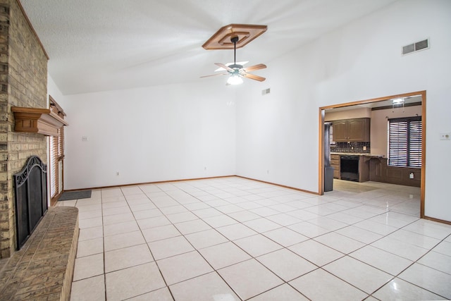 unfurnished living room featuring ceiling fan, visible vents, a fireplace, and light tile patterned floors