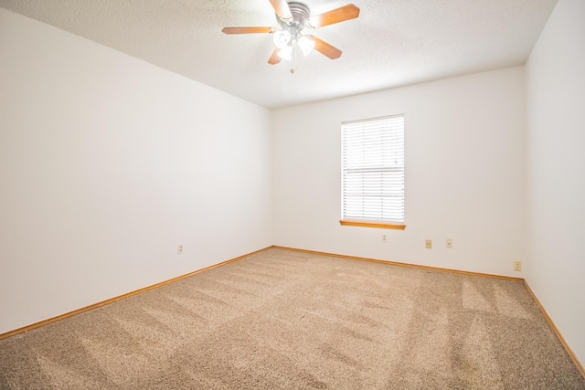 carpeted empty room featuring ceiling fan, a textured ceiling, and baseboards