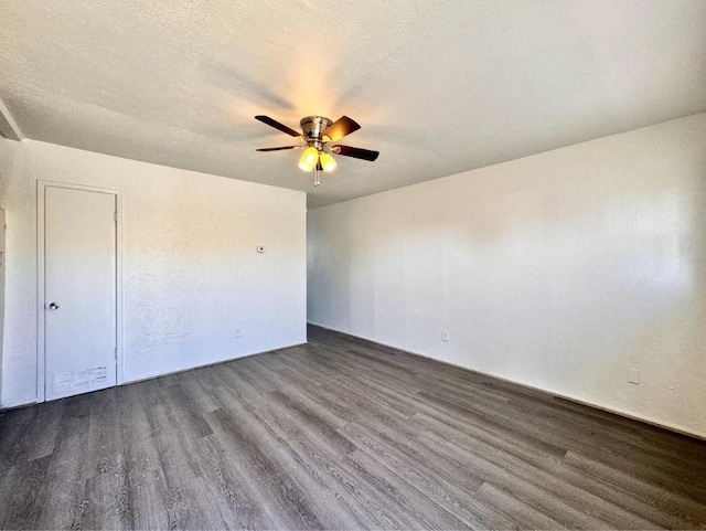 spare room with ceiling fan, dark hardwood / wood-style floors, and a textured ceiling