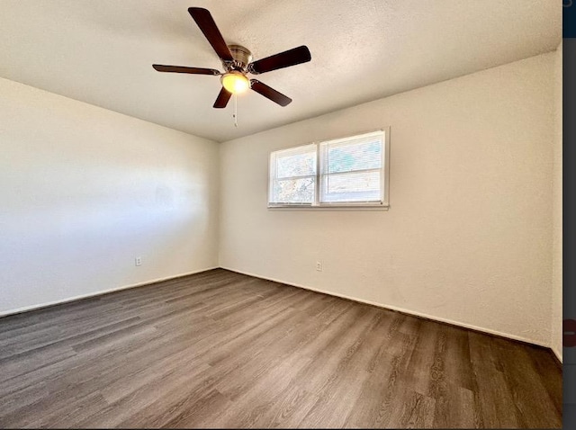 empty room with ceiling fan and wood-type flooring