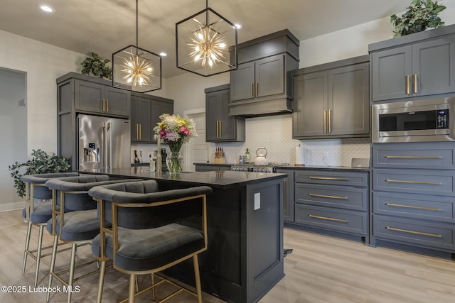 10907 Vicksburg Ave, Lubbock, TX 79424 - kitchen with appliances with stainless steel finishes, backsplash, a kitchen island, light wood finished floors, and recessed lighting