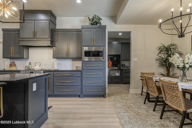10907 Vicksburg Ave, Lubbock, TX 79424 - kitchen with a chandelier, stainless steel microwave, tasteful backsplash, dark countertops, and recessed lighting