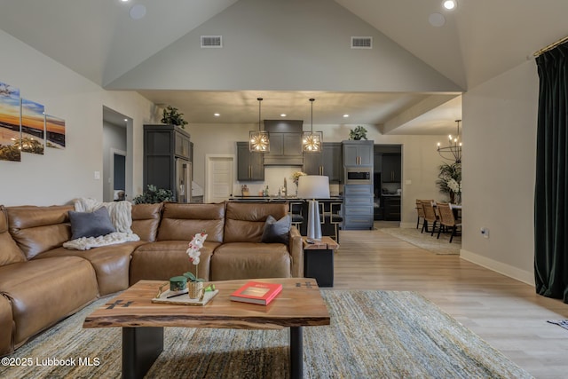 10907 Vicksburg Ave, Lubbock, TX 79424 - living room with light wood-style flooring, a chandelier, recessed lighting, high vaulted ceiling, and baseboards