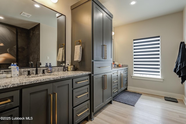 10907 Vicksburg Ave, Lubbock, TX 79424 - bathroom with double vanity, wood finished floors, baseboards, and recessed lighting