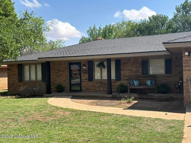 306 Parkwood Ln, Levelland, TX 79336 - ranch-style house featuring a porch, a front yard, roof with shingles, and brick siding