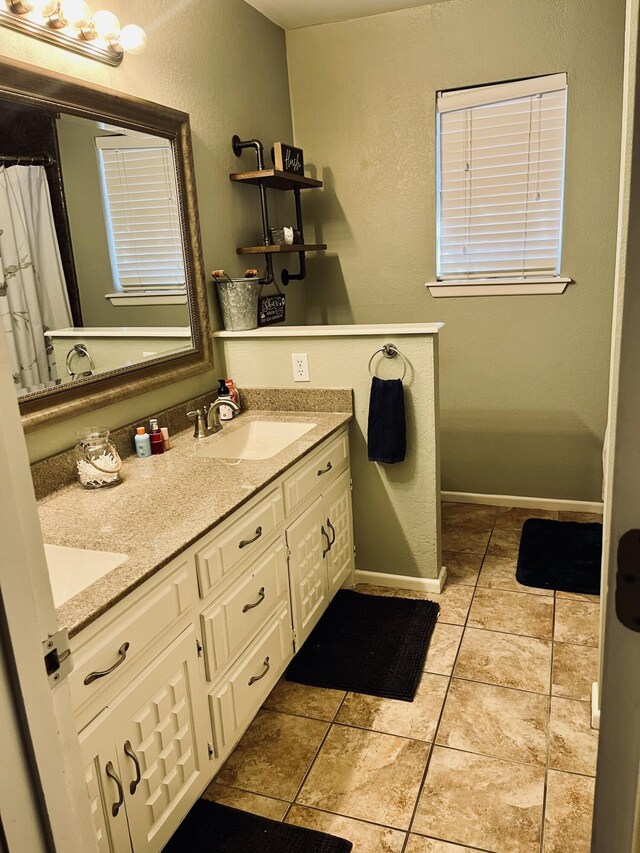 306 Parkwood Ln, Levelland, TX 79336 - bathroom featuring double vanity, a textured wall, and tile patterned flooring