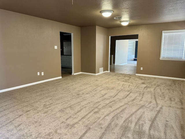 unfurnished room featuring a textured ceiling and carpet