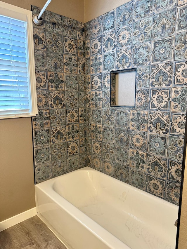 bathroom with a washtub and wood-type flooring