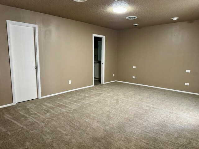 carpeted empty room with a textured ceiling