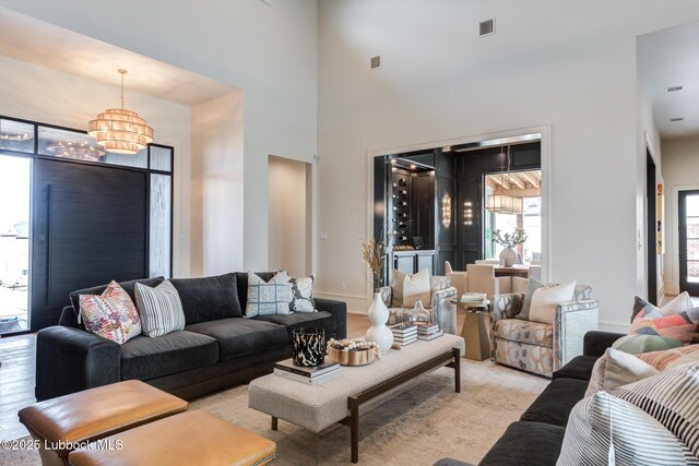 4510 Zadar Ave, Lubbock, TX 79407 - living room featuring a chandelier, light wood finished floors, and a towering ceiling