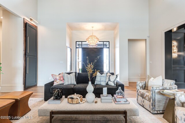 4510 Zadar Ave, Lubbock, TX 79407 - living room with a chandelier, light wood-style floors, and a high ceiling