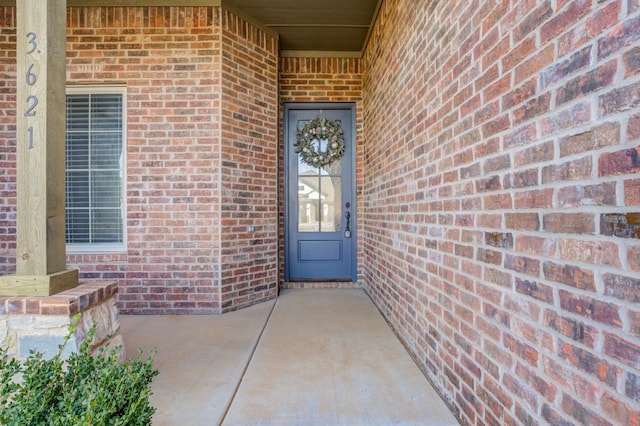 doorway to property featuring brick siding