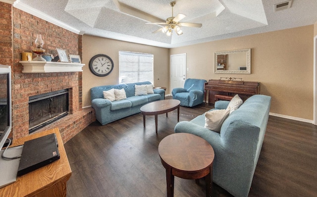 living room with a fireplace, ceiling fan, a raised ceiling, dark wood-type flooring, and a textured ceiling