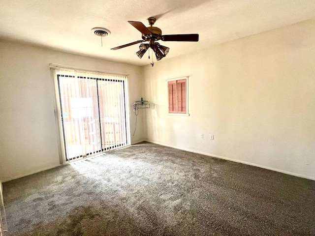 spare room featuring ceiling fan and dark colored carpet