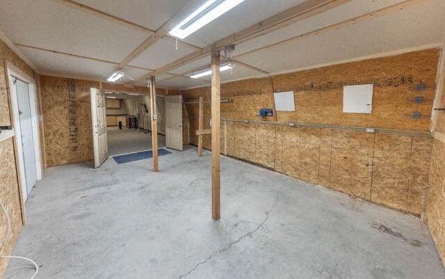 basement featuring wooden walls