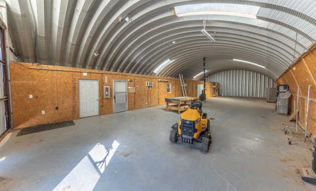 miscellaneous room featuring brick ceiling, lofted ceiling, and concrete floors