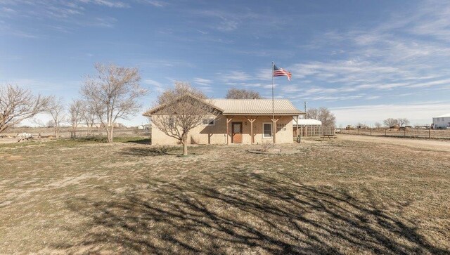 rear view of house with a yard and a rural view