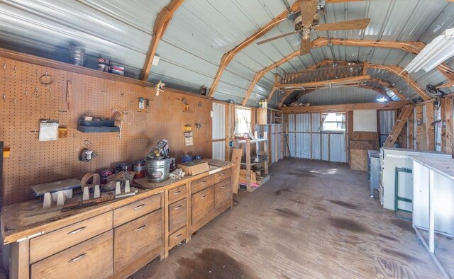 misc room featuring concrete flooring, vaulted ceiling, and a workshop area