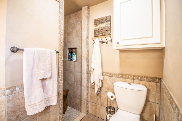 bathroom featuring tile walls and toilet