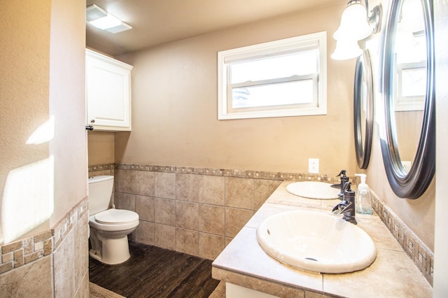 bathroom featuring vanity, toilet, hardwood / wood-style floors, and tile walls