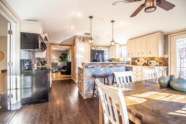 dining space with ceiling fan, stacked washer / dryer, and dark hardwood / wood-style flooring