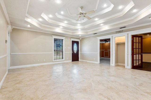 entrance foyer featuring ceiling fan, ornamental molding, and a raised ceiling