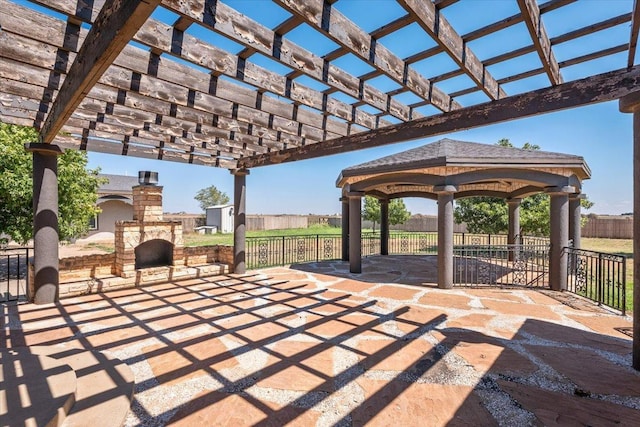 view of patio with an outdoor brick fireplace, a gazebo, and a pergola