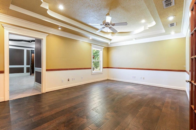 unfurnished room featuring a raised ceiling, crown molding, dark hardwood / wood-style floors, and ceiling fan